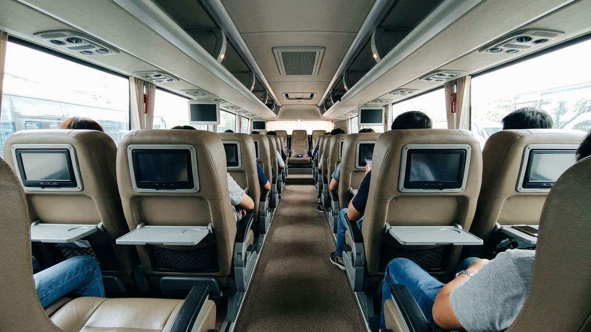 Intérieur d’un bus VIP thaïlandais moderne avec des sièges inclinables, écrans individuels et climatisation