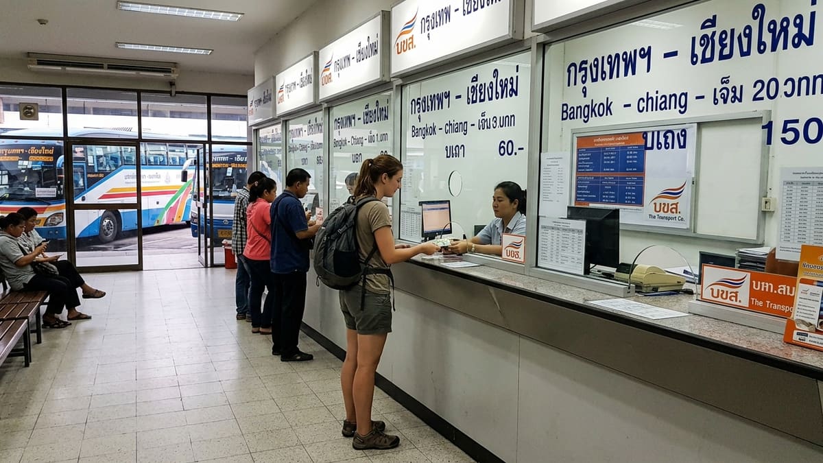 Arrêt de bus thaïlandais en bord de route avec voyageurs et sacs à dos prêts à réserver leur bus pour voyager en Thaïlande